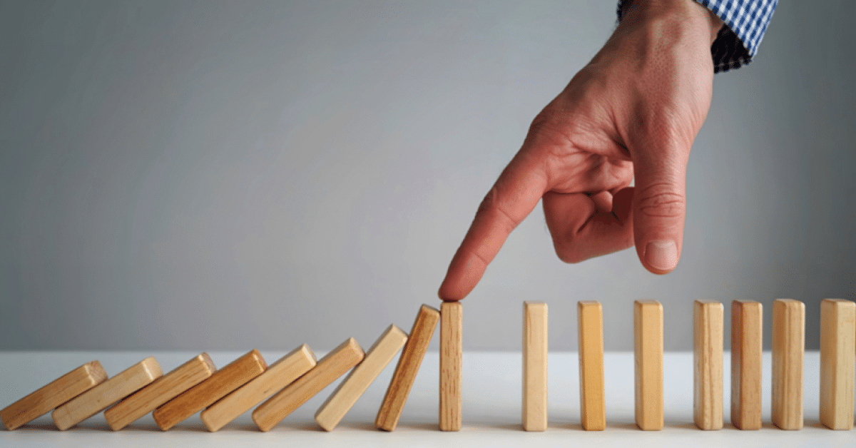 Finger-pushing-dominoes-initiating-a-cascading-effect.png
