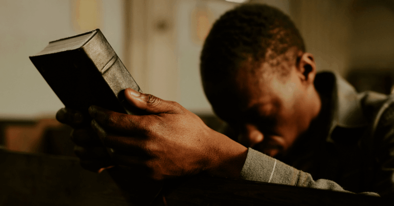 Man-Holding-a-Bible-and-Bowing-His-Head-in-Prayer.png